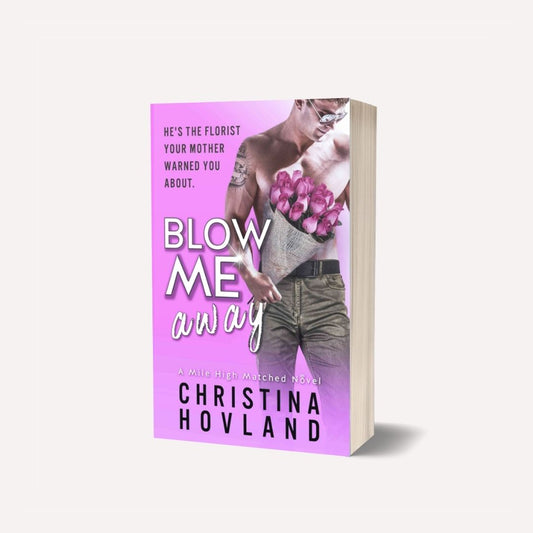 A 3D mockup of a paperback novel, 'Blow Me Away' by Christina Hovland, featuring a vibrant pink cover with a shirtless man holding pink roses, set against a light off-white background.